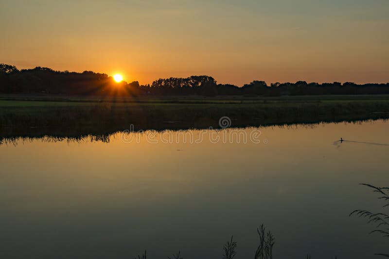 Reflexion av himlen och inställningssolen längs floden Vecht royaltyfri foto Reflexion av himlen och inställningssolen längs floden Vecht royaltyfri foto