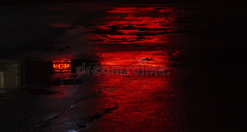 Reflexiones mojadas del asfalto del camino, luz roja fotografía de archivo libre de regalías Reflexiones mojadas del asfalto del camino, luz roja fotografía de archivo libre de regalías