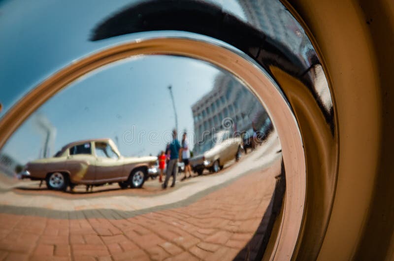 Reflexo distorcido da exposição de veículos retrorreflectores na tampa do espelho da roda de uma das exposições Detalhes de uma c imagem de stock Reflexo distorcido da exposição de veículos retrorreflectores na tampa do espelho da roda de uma das exposições Detalhes de uma c imagem de stock