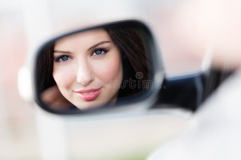 Reflexão da mulher bonita no espelho da lado-vista foto de stock royalty free Reflexão da mulher bonita no espelho da lado-vista foto de stock royalty free