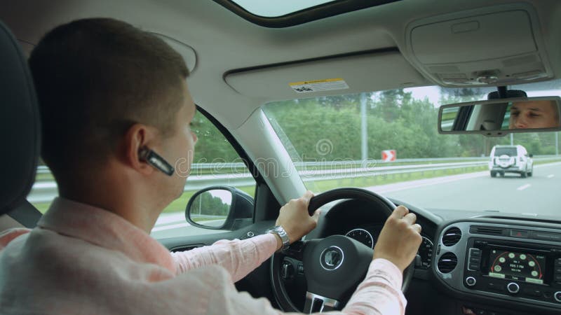 Reflexão no espelho retrovisor do homem que conduz o carro