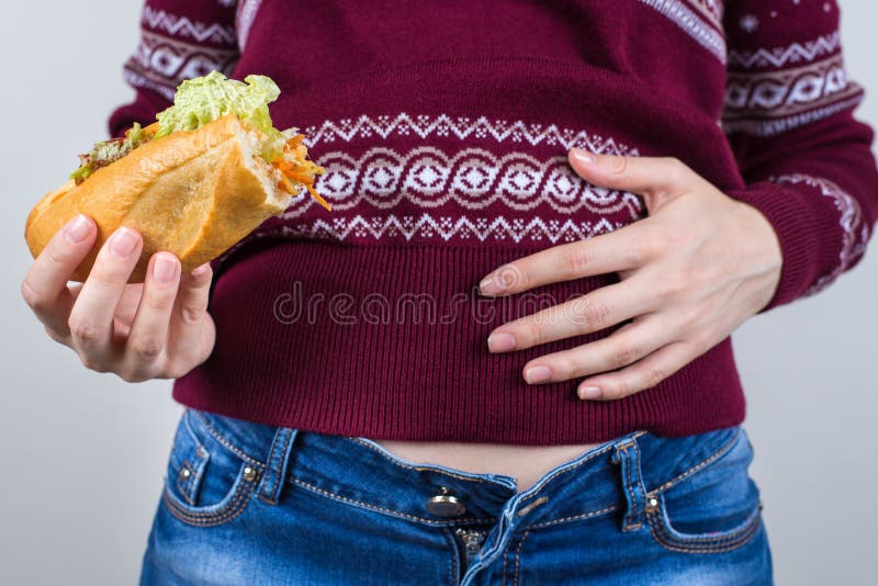 Reflexão sobre o consumo no feriado Foto aproximada de satisfeito, mas não perfeito no abdômen segurando prato grande fotos de stock Reflexão sobre o consumo no feriado Foto aproximada de satisfeito, mas não perfeito no abdômen segurando prato grande fotos de stock
