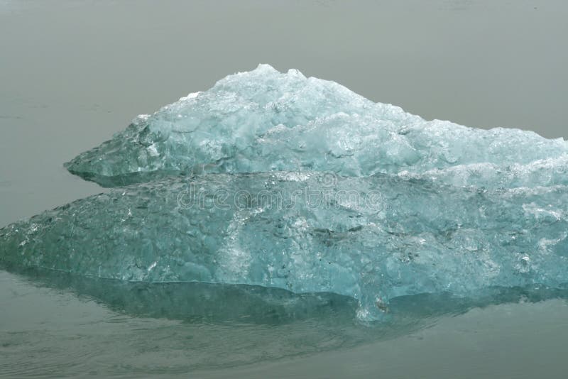 Reflexões dos icerbergs azuis e brancos de cristal na água escura preta na luz sombrio não ofuscante - geleira de Jökulsárlón Jok fotos de stock royalty free Reflexões dos icerbergs azuis e brancos de cristal na água escura preta na luz sombrio não ofuscante - geleira de Jökulsárlón Jok fotos de stock royalty free