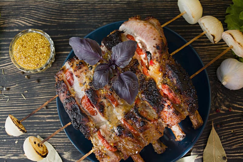 Refor?os de carne de porco grelhados com vegetais e especiarias em um fundo de madeira foto de stock Refor?os de carne de porco grelhados com vegetais e especiarias em um fundo de madeira foto de stock