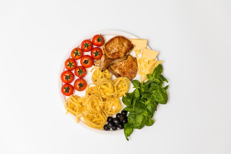 Reforços de carne de porco fritados com espaguetes, tomates de cereja, manjericão, azeitonas e queijo fotos de stock Reforços de carne de porco fritados com espaguetes, tomates de cereja, manjericão, azeitonas e queijo fotos de stock