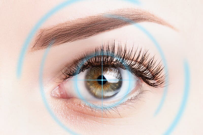 Refractive surgery, eye laser surgery concept. Female eye close up with blue laser rays.