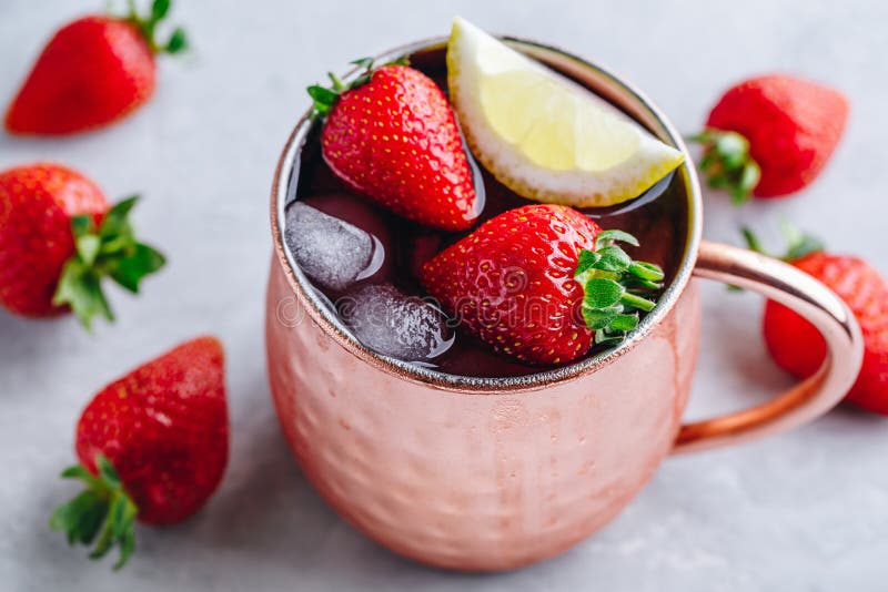 Refreshing iced Moscow mule alcoholic cocktail in copper mugs with strawberry and lemon. On gray stone background royalty free stock photos Refreshing iced Moscow mule alcoholic cocktail in copper mugs with strawberry and lemon. On gray stone background royalty free stock photos