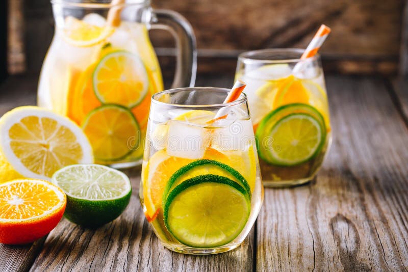 A refreshing summer ice-cold drink. White wine sangria in glass with lime, lemon and orange