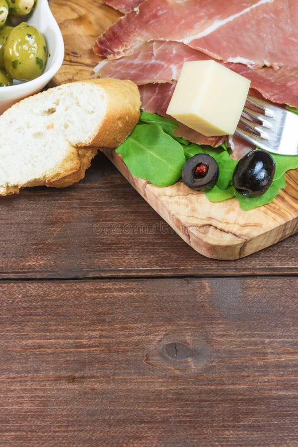 Refreshments of Sliced Spanish Ham and Olives. Vertically. Stock Photo