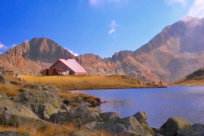 Refugio de la montaña al lado de un lago glacial en el parque nacional Pirin