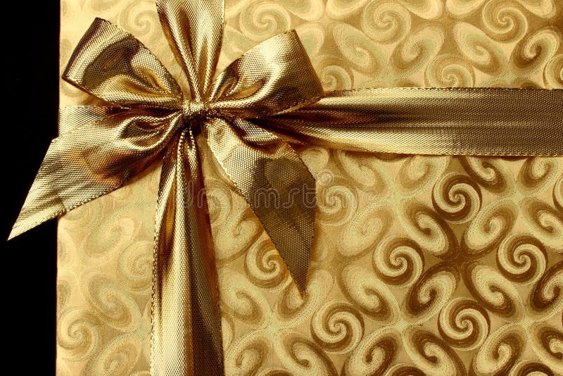 Regalo de la Navidad en papel del oro con el arco Fondo imagen de archivo libre de regalías Regalo de la Navidad en papel del oro con el arco Fondo imagen de archivo libre de regalías