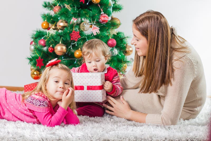 Regalo di feste aperto della famiglia felice di Natale immagini stock Regalo di feste aperto della famiglia felice di Natale immagini stock
