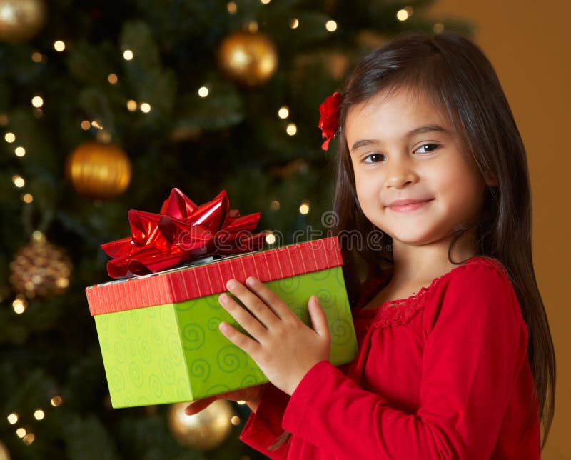 Regalo di Natale della holding della ragazza davanti all'albero fotografia stock libera da diritti
