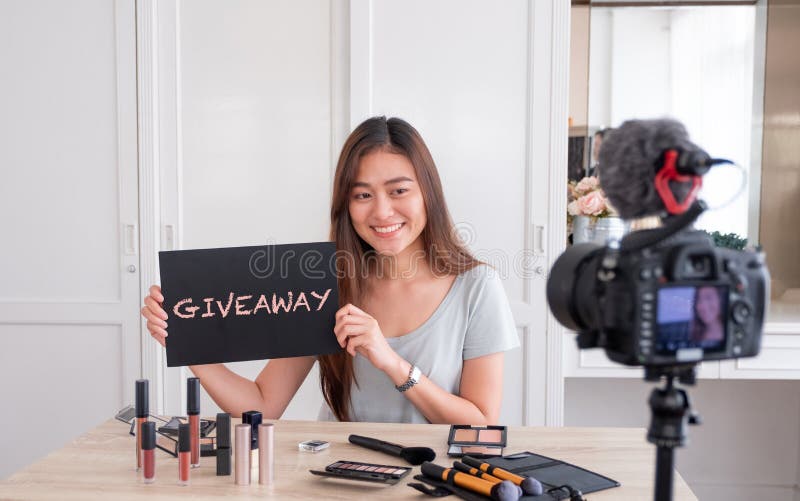 Regalo femenino joven asiático del sorteo del blogger a avivar después de channe fotos de archivo libres de regalías Regalo femenino joven asiático del sorteo del blogger a avivar después de channe fotos de archivo libres de regalías