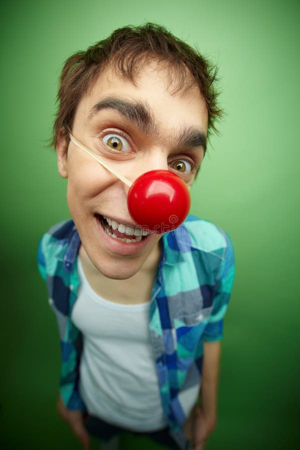 Close-up of a slightly mad guy with clown nose celebrating fools day. Close-up of a slightly mad guy with clown nose celebrating fools day