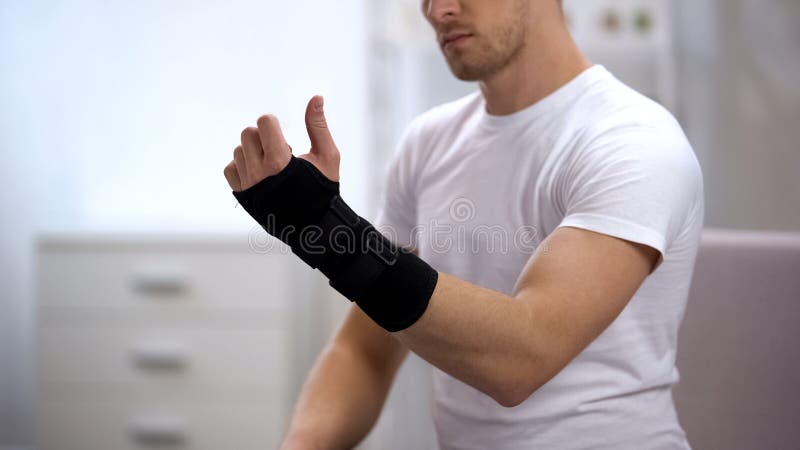 Regard masculin actuel avec l'appui de poignet de titan, équipement orthopédique, traumatisme photo libre de droits Regard masculin actuel avec l'appui de poignet de titan, équipement orthopédique, traumatisme photo libre de droits