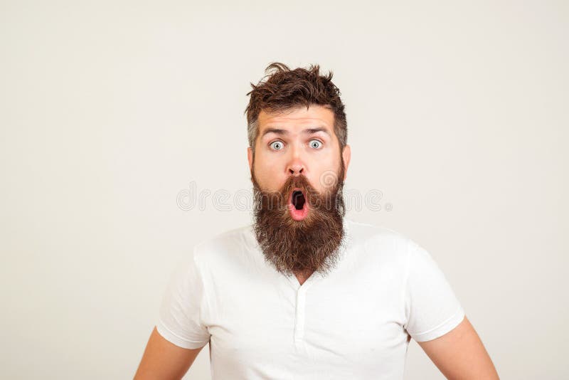 Regards fixes barbus choqués d'homme à la caméra Le type barbu de hippie a largement ouvert la bouche et les yeux Expressions et photo stock Regards fixes barbus choqués d'homme à la caméra Le type barbu de hippie a largement ouvert la bouche et les yeux Expressions et photo stock