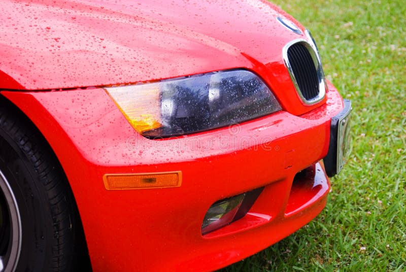 Regen auf einem roten Auto stockbild Regen auf einem roten Auto stockbild