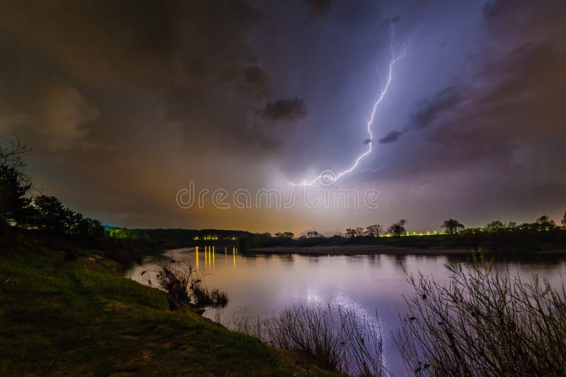 Regen en bliksem boven de rivier stock afbeeldingen