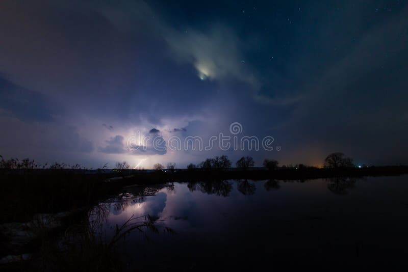 Regen en bliksem boven de rivier stock fotografie