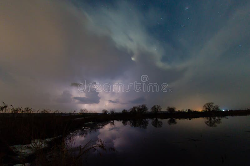 Regen en bliksem boven de rivier stock fotografie