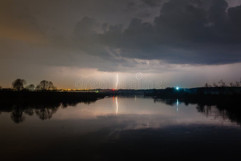 Regen en bliksem boven de rivier stock afbeelding
