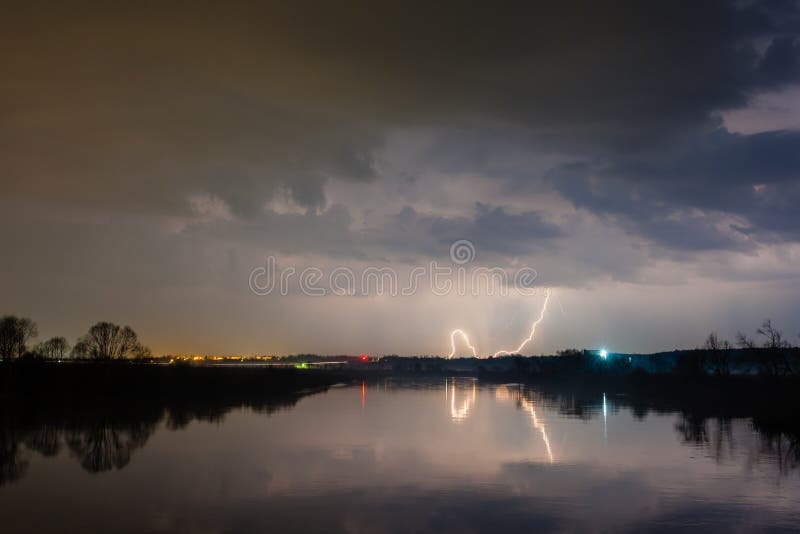 Regen en bliksem boven de rivier stock foto