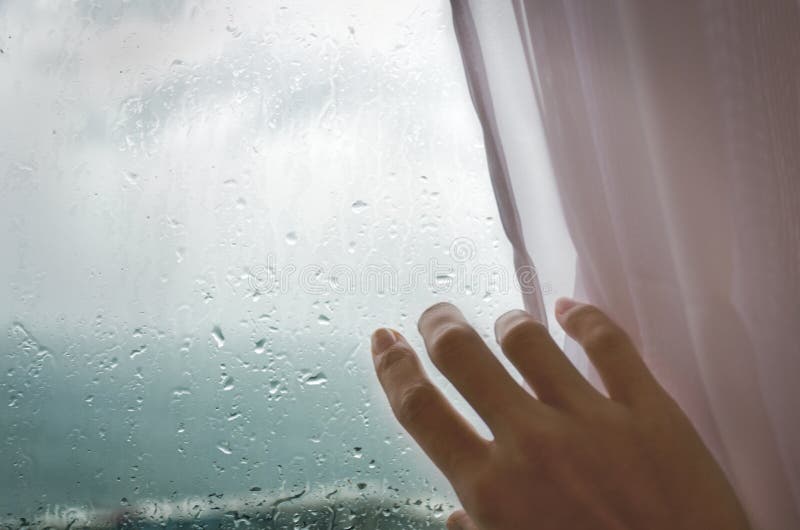 Regenachtig weer - een vrouwen` s hand trekt blinden van het regenachtige venster stock afbeeldingen Regenachtig weer - een vrouwen` s hand trekt blinden van het regenachtige venster stock afbeeldingen