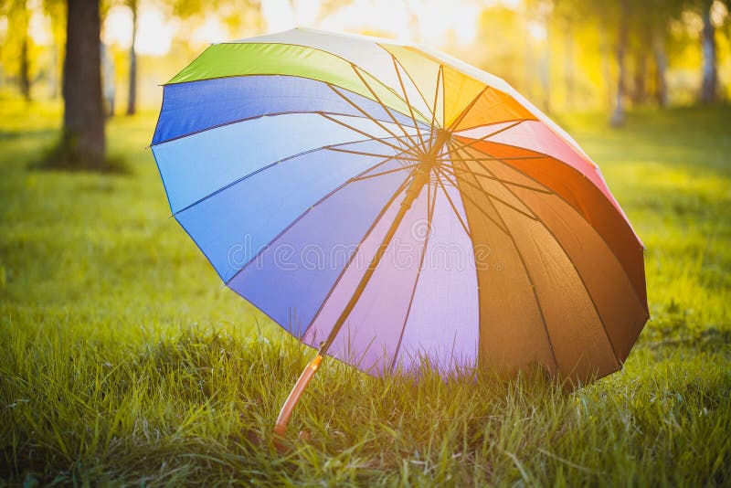 Regenbogenregenschirm auf Hintergrund des grünen Grases lizenzfreies stockfoto Regenbogenregenschirm auf Hintergrund des grünen Grases lizenzfreies stockfoto