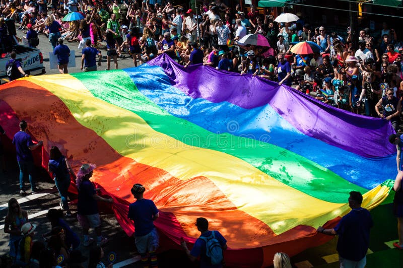Regenboogvlag door mensen wordt gedragen die schenkingen verzamelen tijdens trotsparade die royalty-vrije stock afbeelding Regenboogvlag door mensen wordt gedragen die schenkingen verzamelen tijdens trotsparade die royalty-vrije stock afbeelding
