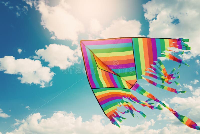 Regnbågedrakeflyg i blå himmel med moln Frihets- och sommarferie fotografering för bildbyråer