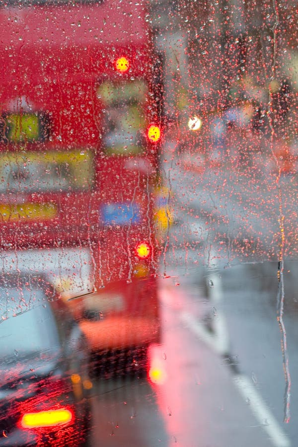 Regnen Sie in London-Ansicht zum roten Bus durch Regen-gesprenkeltes Fenster stockbild Regnen Sie in London-Ansicht zum roten Bus durch Regen-gesprenkeltes Fenster stockbild