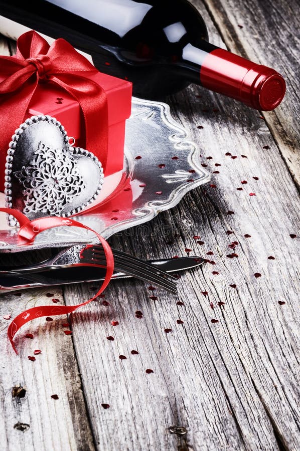 Regolazione della tavola del biglietto di S. Valentino della st con il vino rosso attuale e fotografie stock Regolazione della tavola del biglietto di S. Valentino della st con il vino rosso attuale e fotografie stock