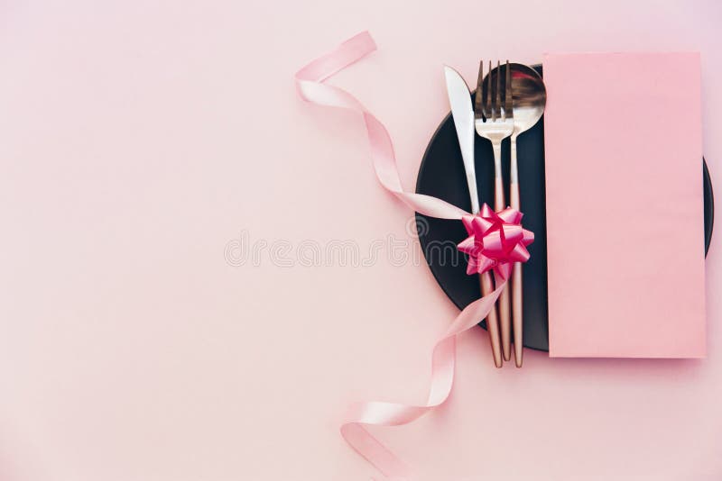 Party table setting. Top view, flat lay over pink background. Menu for restaurant, invitation for dinner or wedding elegant place setting. Party table setting. Top view, flat lay over pink background. Menu for restaurant, invitation for dinner or wedding elegant place setting