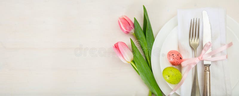 Regolazione della tavola di Pasqua con i tulipani rosa su fondo di legno bianco Vista superiore, spazio della copia, insegna