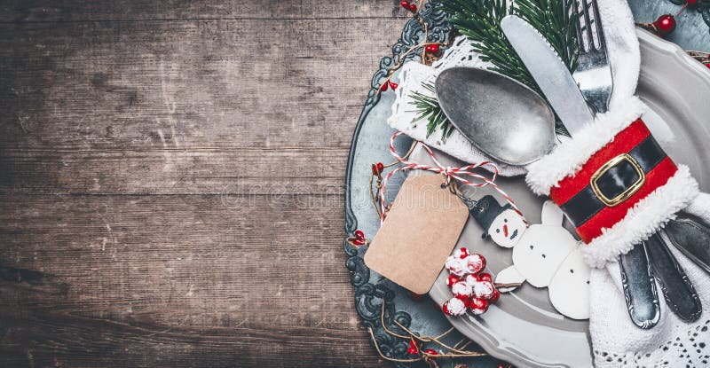 Regolazione di posto d'annata della tavola di cena di Natale con il piatto, la coltelleria, i rami dell'abete, la derisione in bi immagini stock Regolazione di posto d'annata della tavola di cena di Natale con il piatto, la coltelleria, i rami dell'abete, la derisione in bi immagini stock
