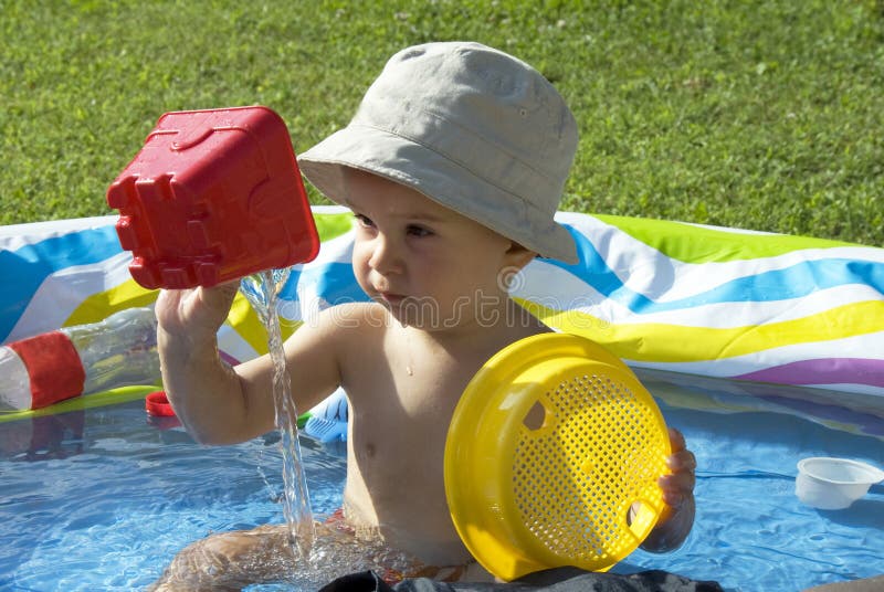 A little boy playing in the pool in his garden. A little boy playing in the pool in his garden