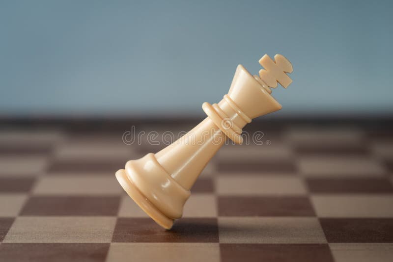 Uma grande peça branca de xadrez está caindo de lado.