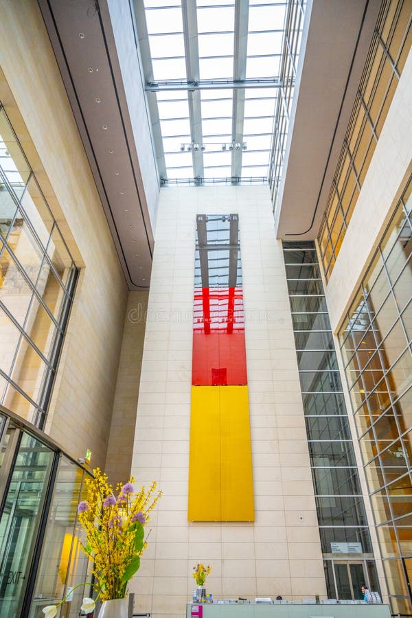 A vertical view of the Reichstag buildings foyer in Berlin, showcasing the modern architecture and German flag. Germany. A vertical view of the Reichstag buildings foyer in Berlin, showcasing the modern architecture and German flag. Germany