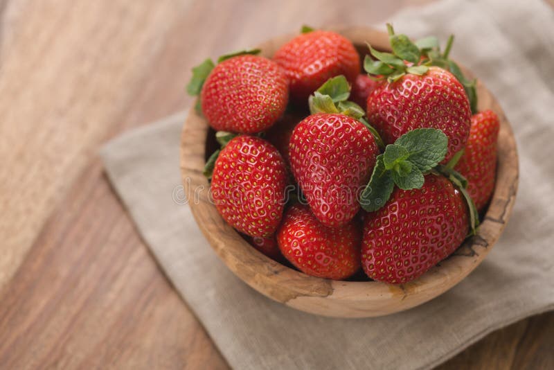 Reife Erdbeeren in der hölzernen Schüssel auf hölzernem Hintergrund mit Kopienraum lizenzfreie stockfotografie Reife Erdbeeren in der hölzernen Schüssel auf hölzernem Hintergrund mit Kopienraum lizenzfreie stockfotografie