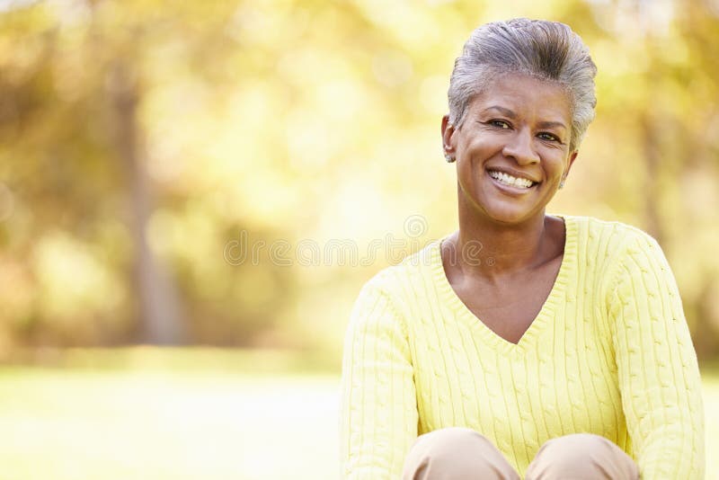 Reife Frau, die in Autumn Landscape sich entspannt lizenzfreies stockfoto Reife Frau, die in Autumn Landscape sich entspannt lizenzfreies stockfoto