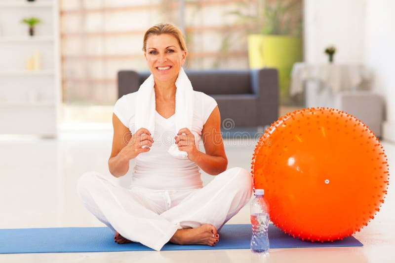 Mature woman resting on exercise mat after fitness workout. Mature woman resting on exercise mat after fitness workout