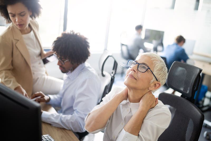 Reife Geschäftsfrau, die Druck und Kopfschmerzen im Büro hat stockbild Reife Geschäftsfrau, die Druck und Kopfschmerzen im Büro hat stockbild