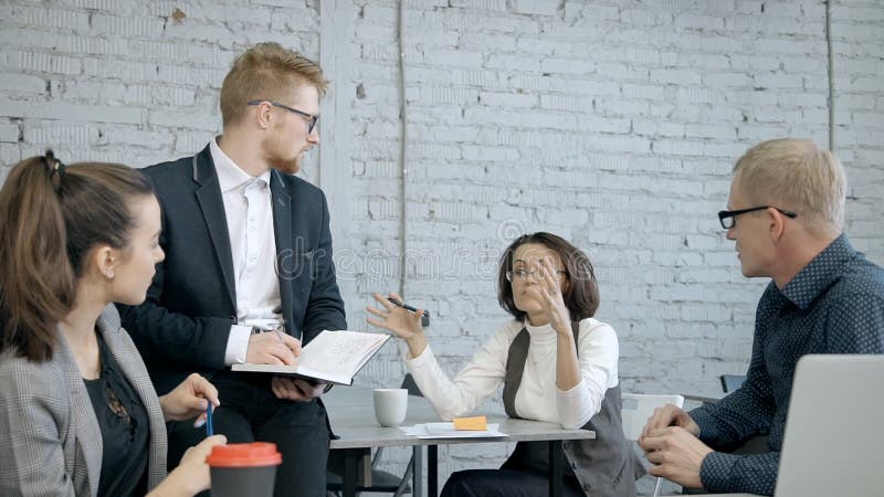 Reife Geschäftsfrau, die neues Projekt oder Strategie mit peo bespricht