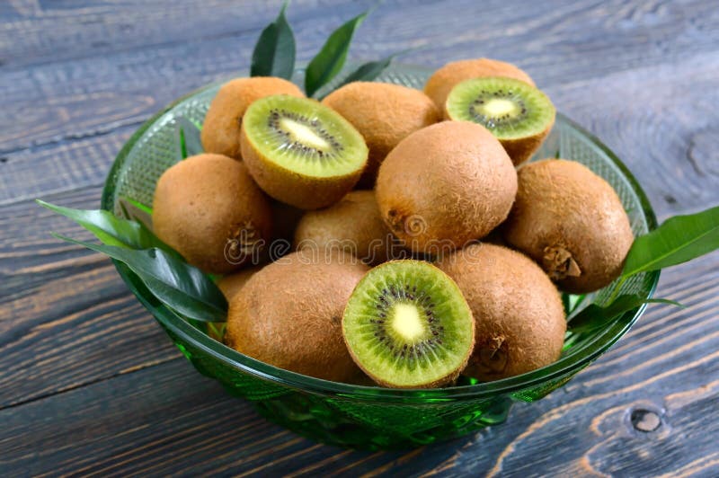 Reife Kiwi in einer grünen Schüssel auf einem Holztisch lizenzfreie stockfotografie Reife Kiwi in einer grünen Schüssel auf einem Holztisch lizenzfreie stockfotografie