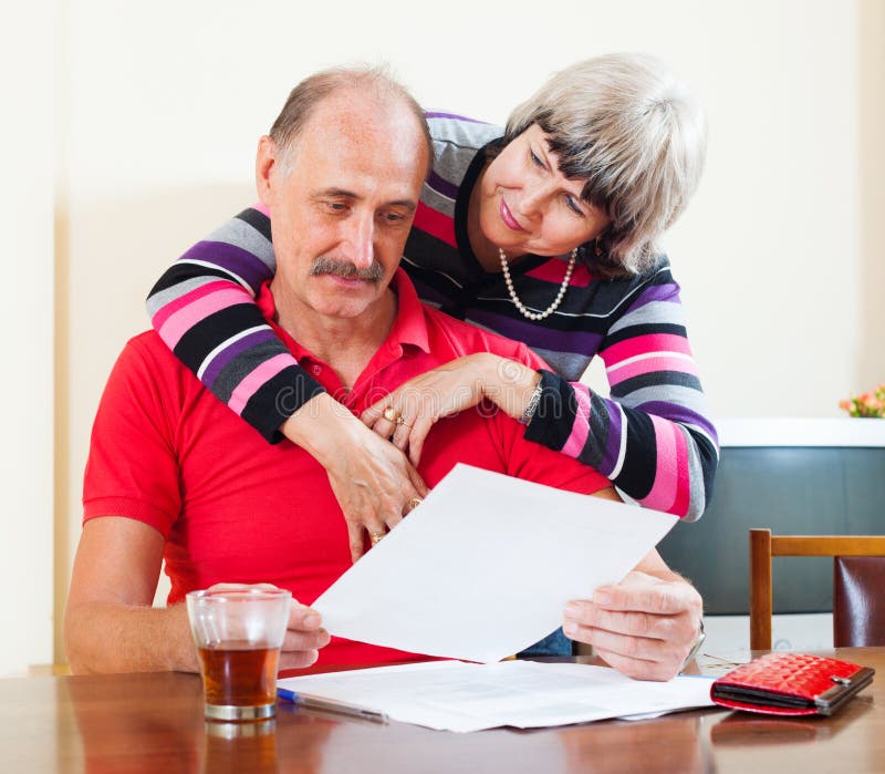 Reife Paare mit Finanzdokumenten lizenzfreies stockfoto Reife Paare mit Finanzdokumenten lizenzfreies stockfoto