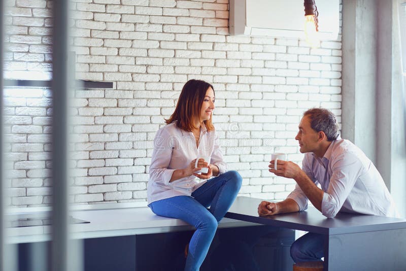 Reife Paare mit Tasse Kaffee zuhause lizenzfreie stockfotografie Reife Paare mit Tasse Kaffee zuhause lizenzfreie stockfotografie