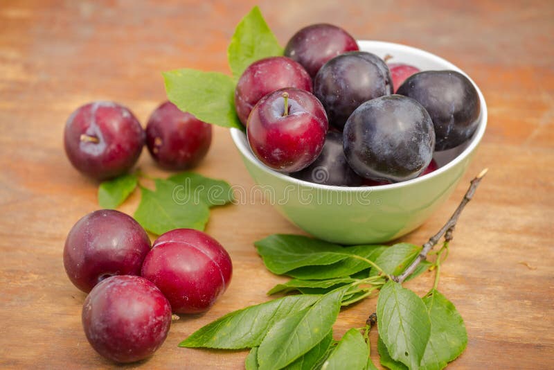 Reife rote und blaue Pflaumen in einer Schüssel auf einem Holztisch lizenzfreies stockfoto Reife rote und blaue Pflaumen in einer Schüssel auf einem Holztisch lizenzfreies stockfoto