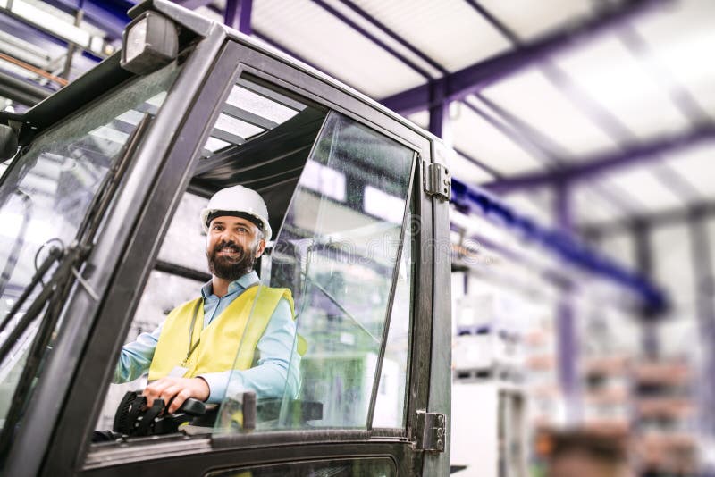 Reifer industrieller Manningenieur, der in einem Gabelstapler in einer Fabrik sitzt stockfoto Reifer industrieller Manningenieur, der in einem Gabelstapler in einer Fabrik sitzt stockfoto