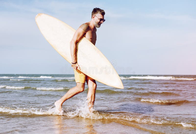 Reifer Mann, der ein Surfbrett trägt lizenzfreie stockfotos Reifer Mann, der ein Surfbrett trägt lizenzfreie stockfotos